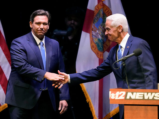 Florida Republican Gov. Ron DeSantis, left, shakes hands with former Gov. Charlie Crist, D