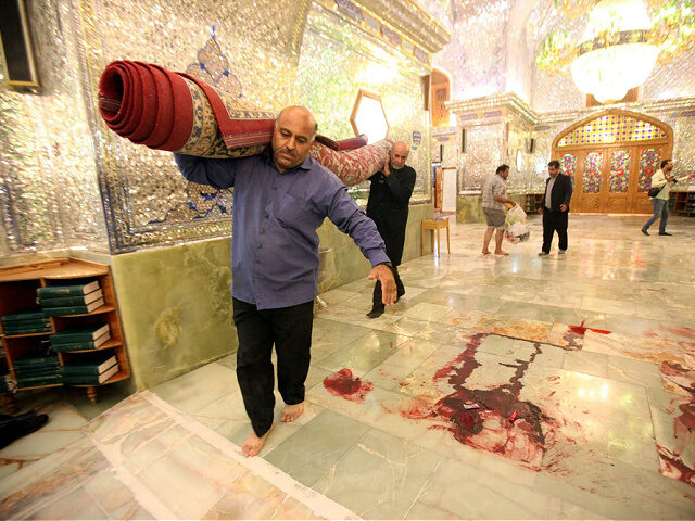 TOPSHOT - Workers clean up the scene following an armed attack at the Shah Cheragh mausoleum in the Iranian city of Shiraz on October 26, 2022. - At least 15 people were killed in an attack on a key Shiite Muslim shrine in southern Iran, state media said, with the …