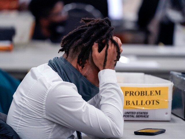 An elections worker rubs his head in the closing hours where absentee ballots were processed at the central counting board, Nov. 4, 2020, in Detroit. Voters in some battleground states will be deciding ballot proposals in November 2022 that could reshape the way votes are cast in the 2024 presidential …