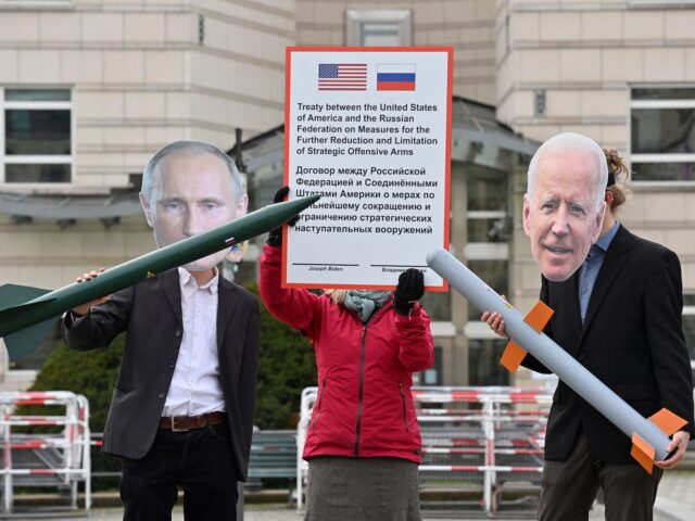 Peace activists wearing masks of Russian President Vladimir Putin (L) and newly elected US President Joe Biden pose with mock nuclear missiles in front of the US embassy in Berlin on January 29, 2021 in an action to call for more progress in nuclear disarmament. - The Russian parliament on …