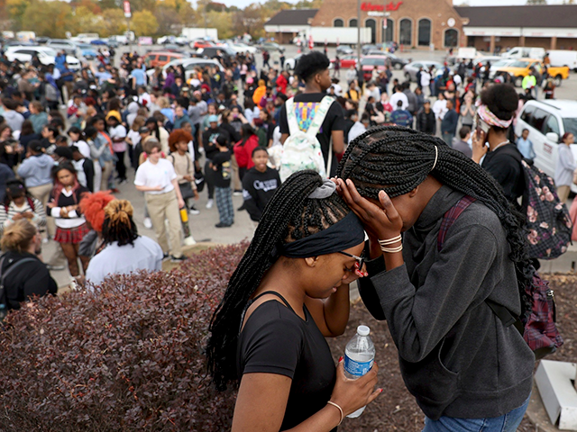 Students stand in a parking lot near the Central Visual & Performing Arts High School