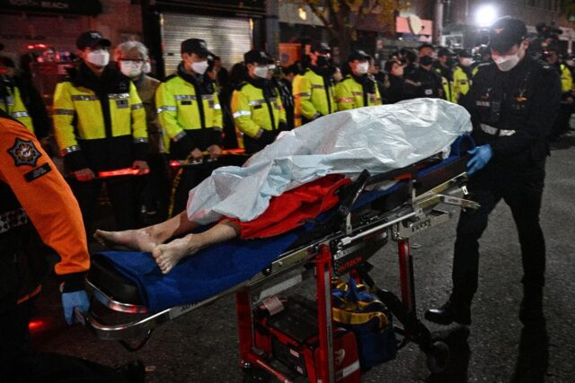 The body of a victim of a Halloween stampede is carried on a stretcher in Seoul on October