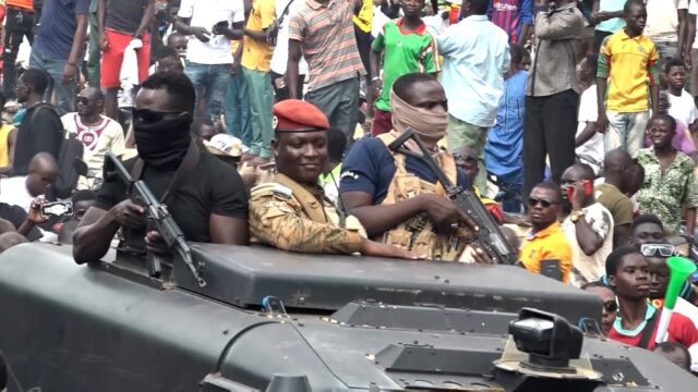 Captain Ibrahim Traore (C), parades in the streets of Ouagadougou and hails the cheering c