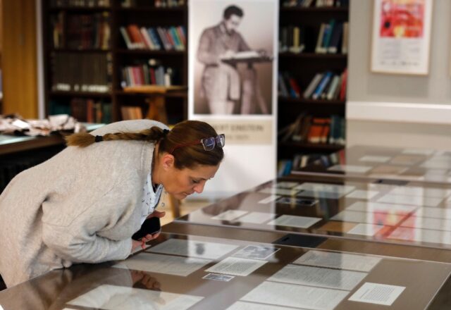 In this file photo from March 6, 2019, a woman checks Albert Einstein manuscripts at the H