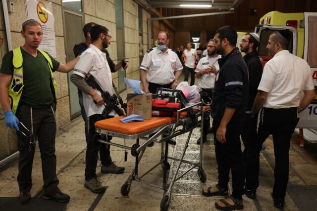 Israeli first responders gather outside the Hadassah Ein Kerem Hospital in Jerusalem follo