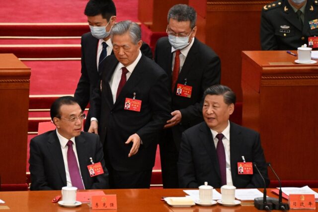 Former president Hu Jintao is reluctantly led out of the 20th Party Congress closing cerem