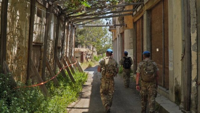 United Nations peacekeepers patrol inside the buffer zone between the internationally reco
