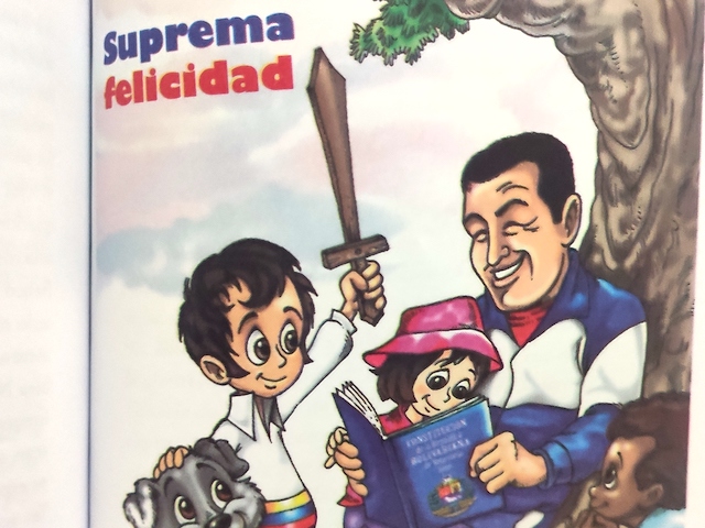 A copy of an illustrated children's Venezuelan constitution featuring Children and a dog sitting around late dictator Hugo Chávez. The caption reads "Supreme Happiness."