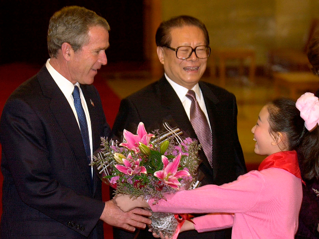 FILE - U.S. then President George W. Bush, left, is given flowers as Chinese then President Jiang Zemin, center, greets Bush upon his arrival in Beijing, Feb. 21, 2002. Chinese state TV said Wednesday, Nov. 30, 2022, that Jiang has died at age 96. (AP Photo/Kenneth Lambert, File)