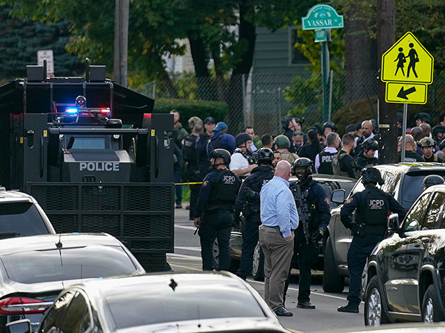 Law enforcement personnel gather at the scene where two officers were reported shot, Tuesd