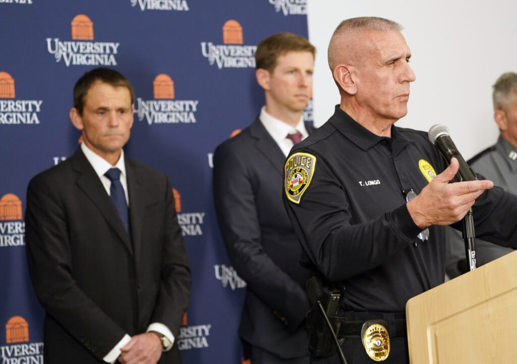 Tim Longo, UVA's Vice President for Safety and Security and Chief of Police, speaks to the media as University of Virginia President Jim Ryan listens, left, listens during a news conference at the school Monday, Nov. 14, 2022 in Charlottesville. Va. Authorities say three people have been killed and two others were wounded in a shooting at the University of Virginia and a student is in custody. (AP Photo/Steve Helber)