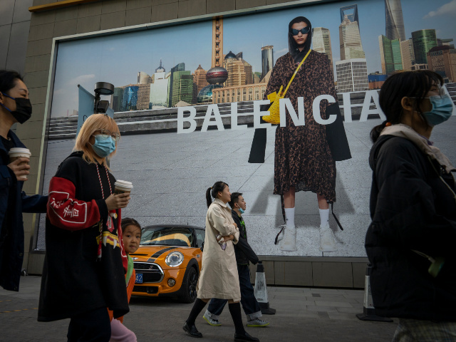 BEIJING, CHINA - OCTOBER 16: People walk in front of a Balenciaga ad on October 16, 2021 in Beijing, China. According to an action plan released on October 14, Beijing has unveiled a series of measures aimed at building the city into an international consumption center over the next five …