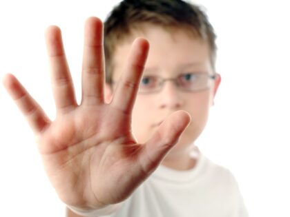 Boy with hand against a glass door