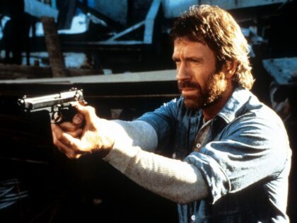 Chuck Norris points a gun in a scene from the film 'Hero And The Terror', 1988.