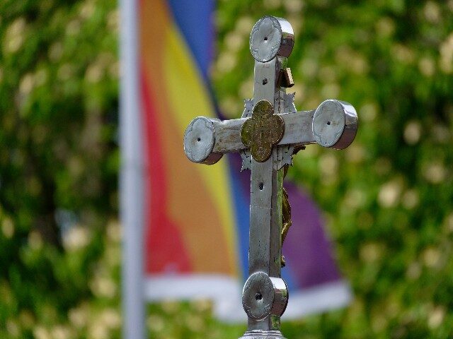 A cross stands in front of Christ's Resurrection Church during an open-air blessing service for lovers. A rainbow flag can be seen in the background. Photo: Henning Kaiser/dpa (Photo by Henning Kaiser/picture alliance via Getty Images)