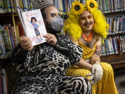 Drag queens Just JP, left, and Sham Payne read stories to children during a Drag Queen Story Hour at Chelsea Public Library in Chelsea, Massachusetts, on June 25, 2022. In the past few months, many drag queens have experienced increased fear and threats. (Erin Clark/The Boston Globe via Getty Images)