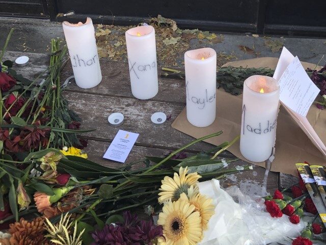 Candles and flowers are left at a makeshift memorial honoring four slain University of Ida
