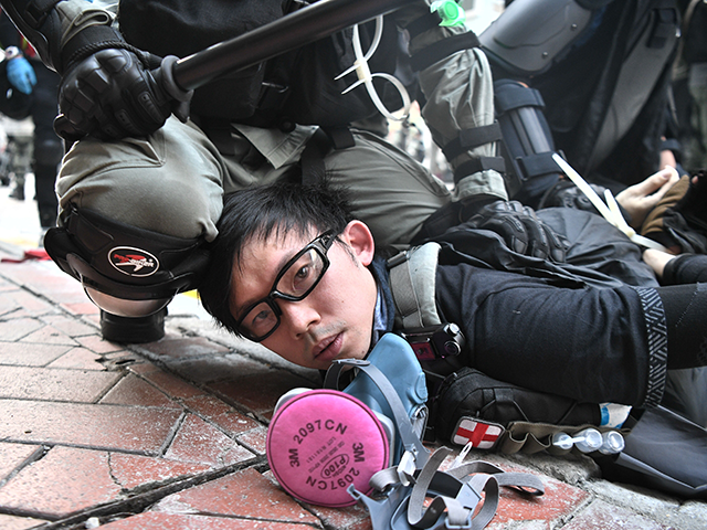 TOPSHOT - A protester is detained by police as violent demonstrations take place in the st