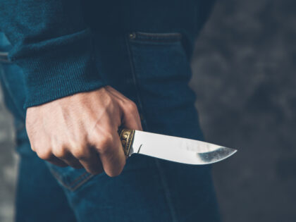 man hand holding knife on abstract background