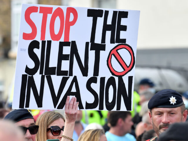 TOPSHOT - An anti-immigation protester holds up a placard during a demo in Dover on the so