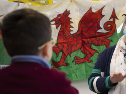 CARDIFF, WALES - MARCH 03: A child has a reading lesson with a teacher wearing a face mask
