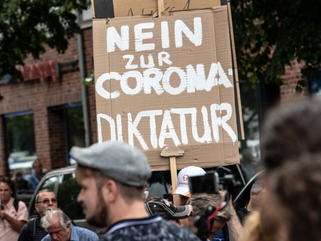 Participants march with a placard reading 'No to the corona dictatorship' during an anti-lockdown protest in Berlin on August 1, 2021. - Berlin police clashed with Covid sceptics on August 1 after hundreds of them took to the streets despite a court-ordered protest ban over concerns participants would not respect …