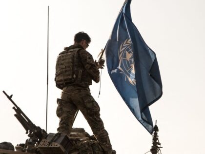 A British soldier of the United Nations Multidimensional Integrated Stabilization Mission in Mali (MINUSMA), adjusts a UN flag on the roof of a light armoured vehicle during a patrol in Menaka, Mali, on October 28, 2021. (Photo by FLORENT VERGNES / AFP) (Photo by FLORENT VERGNES/AFP via Getty Images)