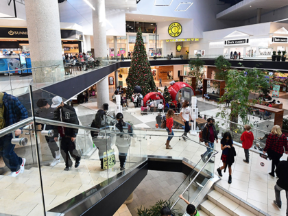 People walk at a shopping mall in Santa Anita, California on December 20, 2021. (Photo by