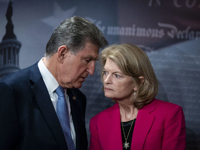 Senator Joe Manchin, a Democrat from West Virginia, left, speaks to Senator Lisa Murkowski