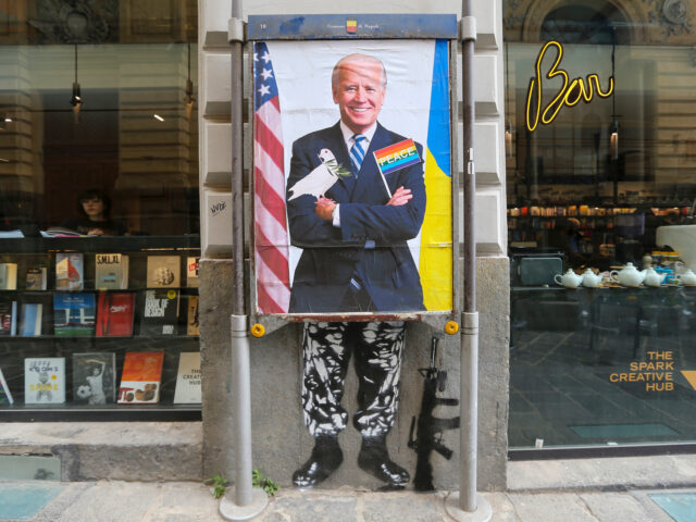 NAPLES, ITALY - 2022/05/02: The president of the United States of America, Joe Biden, depicted in the work of the Neapolitan street artist, Eduardo Castaldo, as half pacifist and half warmonger, over - with a peace flag and a dove, under - with military trousers, next to a machine gun. …