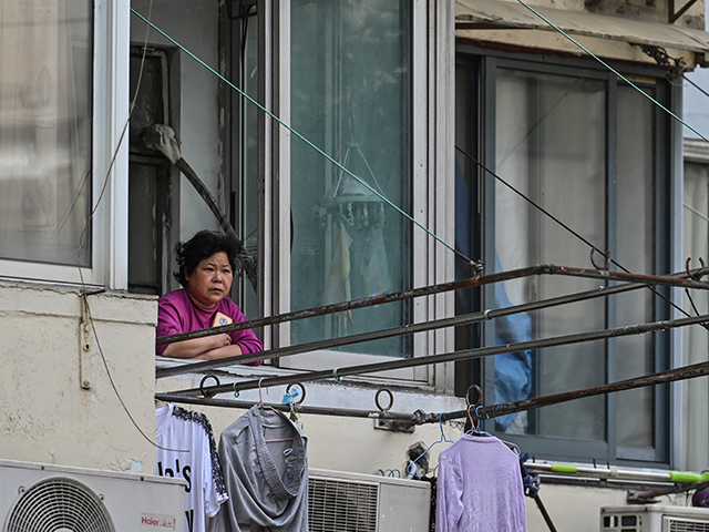 A resident looks out from her window during a Covid-19 coronavirus lockdown in the Jing&#0