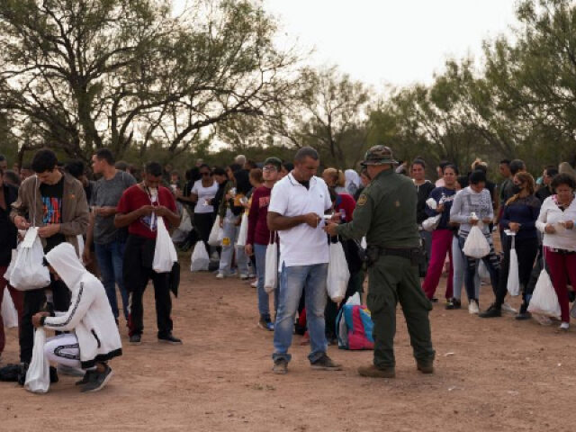 Migrants are processed by US Border Patrol after they illegally crossed the US southern border with Mexico on October 9, 2022 in Eagle Pass, Texas. - In the 2022 fiscal year US Customs and Border Patrol (CBP) has had over 2 million encounters with migrants at the US-Mexico border, setting …