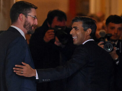 Britain's newly appointed Prime Minister Rishi Sunak (C) is greeted by Britain's Cabinet S