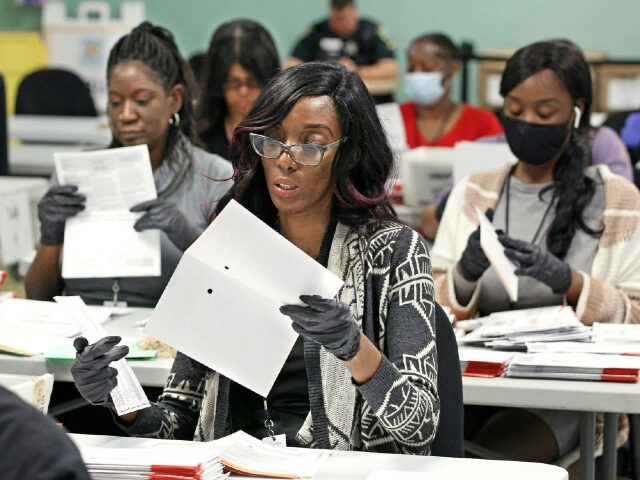 Election workers separate verified ballots from their envelopes at the Orange County Super