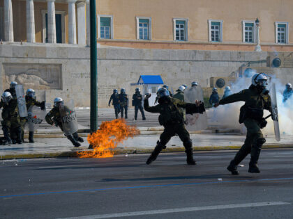ATHENS, ATTIKI, GREECE - 2022/11/09: A policeman seen throwing a flash grenade at Syntagma