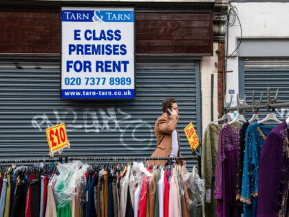 A clothing stall on the street in front of a shuttered retail unit for rent at Petticoat Lane Market in London, UK, on Friday, Nov. 11, 2022. The UK economy shrank in the third quarter for the first time since the final lockdown of the pandemic as the cost of …