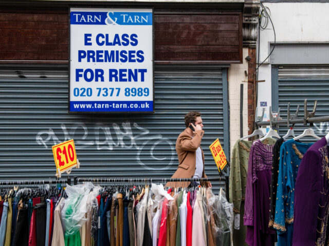A clothing stall on the street in front of a shuttered retail unit for rent at Petticoat L