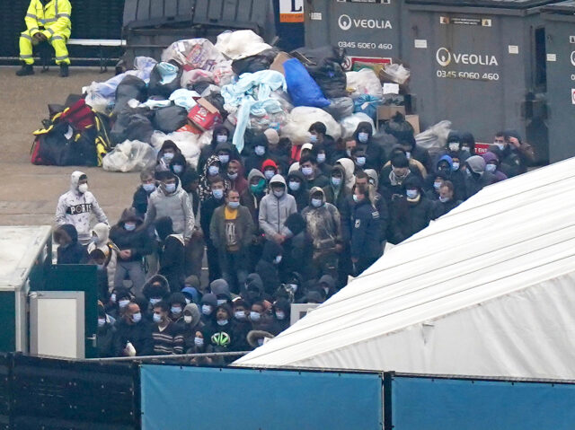 A group of people thought to be migrants wait to be processed after being brought in to Dover, Kent, onboard a Border Force vessel, following a small boat incident in the Channel. Picture date: Monday November 14, 2022. (Photo by Gareth Fuller/PA Images via Getty Images)