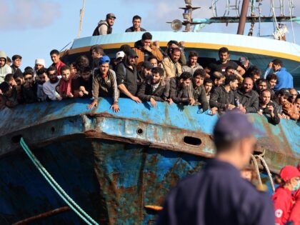 Rescued refugees and migrants stand aboard a boat at the town of Paleochora, southwestern Crete island on November 22, 2022, following a rescue operation. (Photo by Costas METAXAKIS / AFP) (Photo by COSTAS METAXAKIS/AFP via Getty Images)
