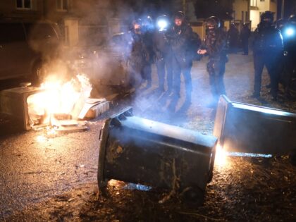 26 November 2022, Saxony, Leipzig: Police officers stand by burning trash containers during a demonstration. Participants of a left-wing demonstration blocked a right-wing march in Leipzig. The initiators of the right-wing demonstration under the slogan "Ami go home" demand that the USA withdraw its troops and nuclear weapons on German …