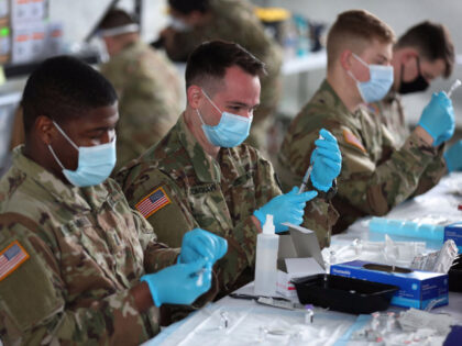 NORTH MIAMI, FLORIDA - MARCH 09: U.S. Army soldiers from the 2nd Armored Brigade Combat Team, 1st Infantry Division, prepare Pfizer COVID-19 vaccines to inoculate people at the Miami Dade College North Campus on March 09, 2021 in North Miami, Florida. The soldiers deployed to assist the Federal Emergency Management …