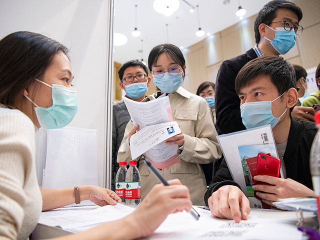 Graduates wearing face masks attend a four-day annual campus job fair at Tsinghua University on March 17, 2021 in Beijing, China. (Photo by Hou Yu/China News Service via Getty Images)