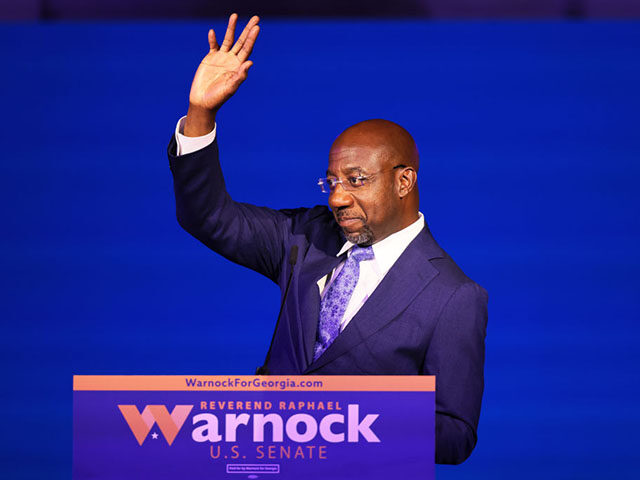 ATLANTA, GEORGIA - NOVEMBER 08: Sen. Raphael Warnock (D-GA) waves after giving a speech at his Election night party at Atlanta Marriott Marquis on November 08, 2022 in Atlanta, Georgia. Sen. Warnock is in a very tight race with Republican challenger Herschel Walker. If neither candidate receives 50 percent plus …