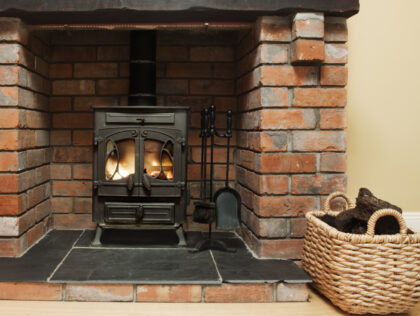 Authentic brick walled fireplace with a stove ,, peat in the basket