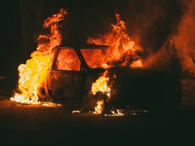 Abandoned car on fire in the dark