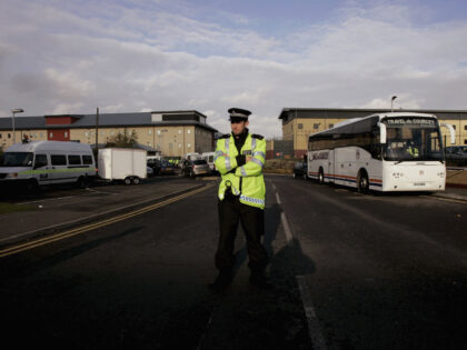 MIDDLESEX, UNITED KINGDOM - NOVEMBER 29: A police officer stands guard at the entrance to Harmondsworth Immigration Detention centre on November 29, 2006 in Middlesex, England. Small fires were started in the UK's largest immigration removal centre resulting in violent clashes between the police force and detainees. (Photo by Bruno …