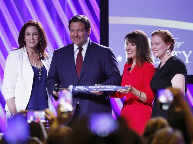 Moms for Liberty founders Tiffany Justice (L) and Tina Descovich present the Liberty Sword to Governor Ron DeSantis before he speaks during the inaugural Moms for Liberty Summit at the Tampa Marriott Water Street on July 15, 2022, in Tampa, Florida. DeSantis is up for reelection in the 2022 Gubernatorial …