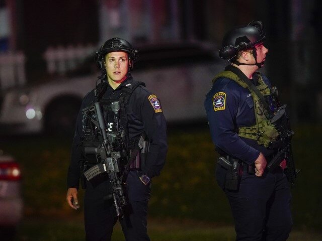 Law enforcement personnel gather at the scene where two officers were reported shot, Tuesd