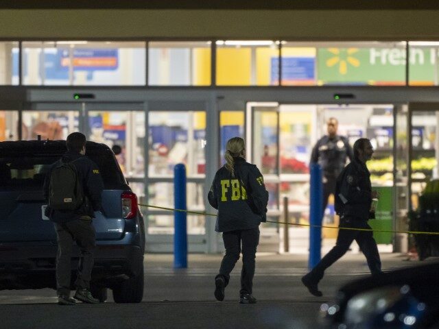 Law enforcement, including the FBI, work the scene of a mass shooting at a Walmart, Wednes