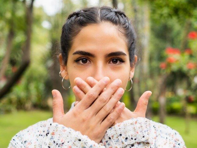 Young woman covering her mouth with her hands